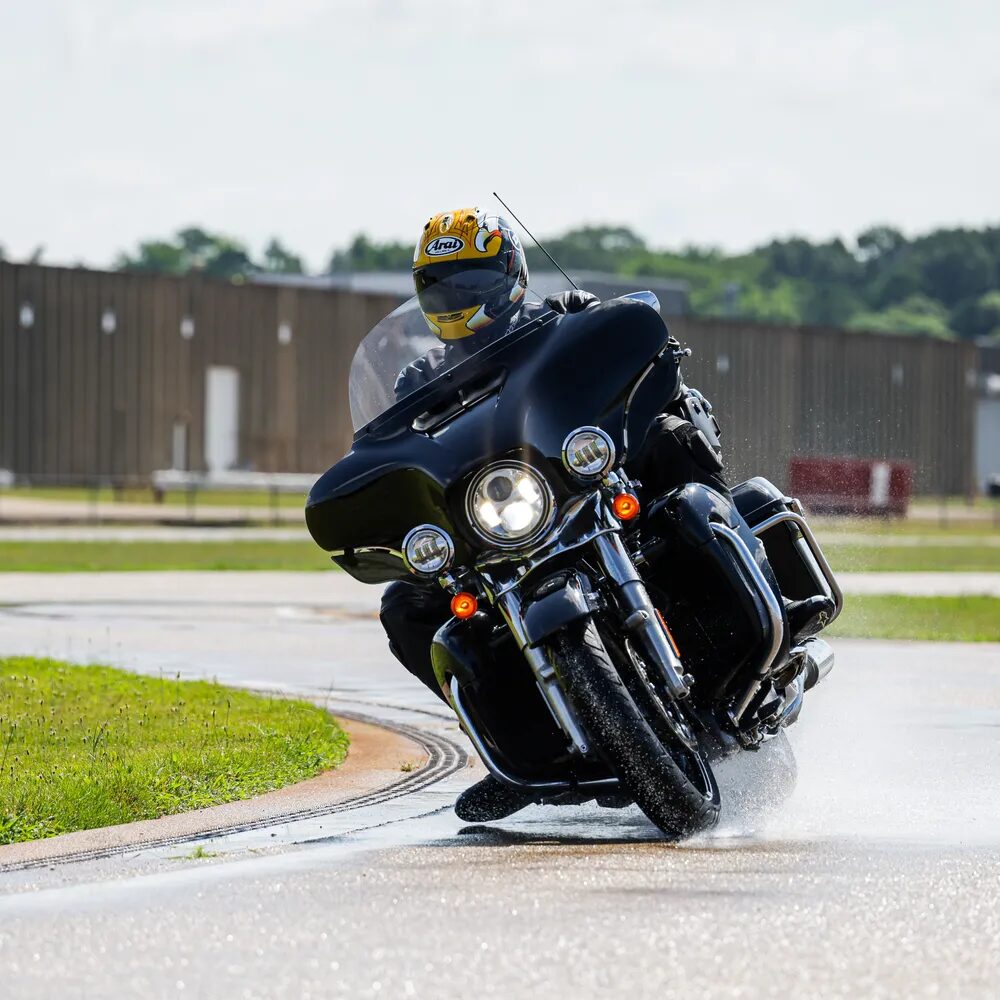 Motorcycle rider testing on a wet proving-ground track