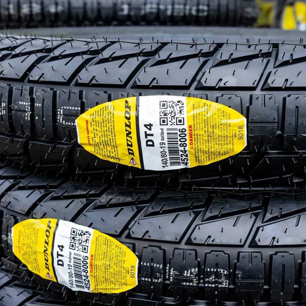 Stacked Dunlop motorcycle tires with product labels